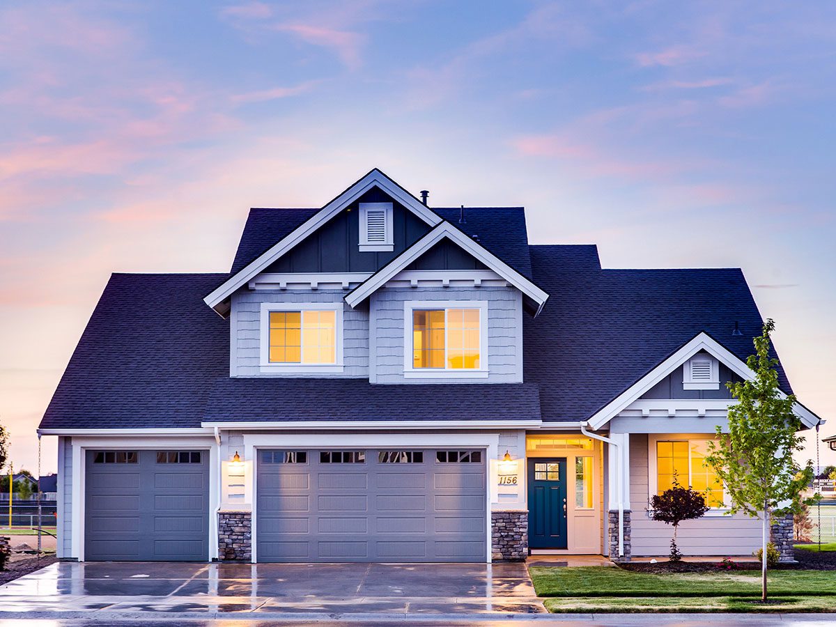 front of blue and gray house with double and single garage doors