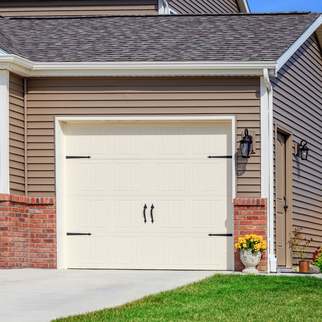 a tan garage door with black hardware