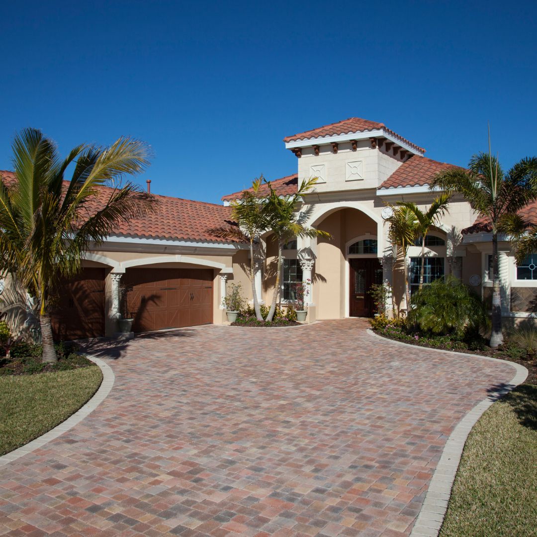 a Tuscan style home with dark wood garage doors